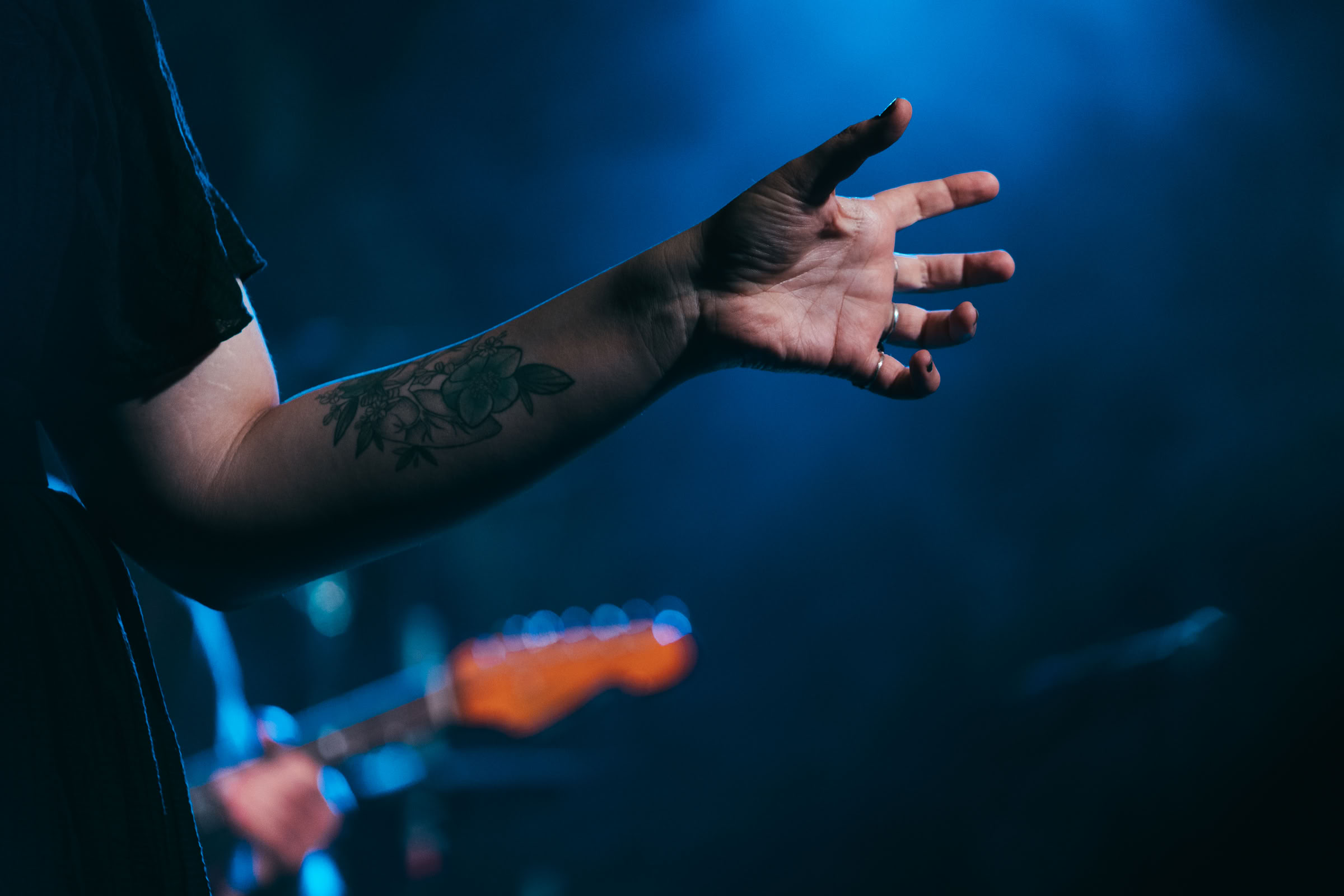 Braccio teso — tatuaggio floreale, luce blu